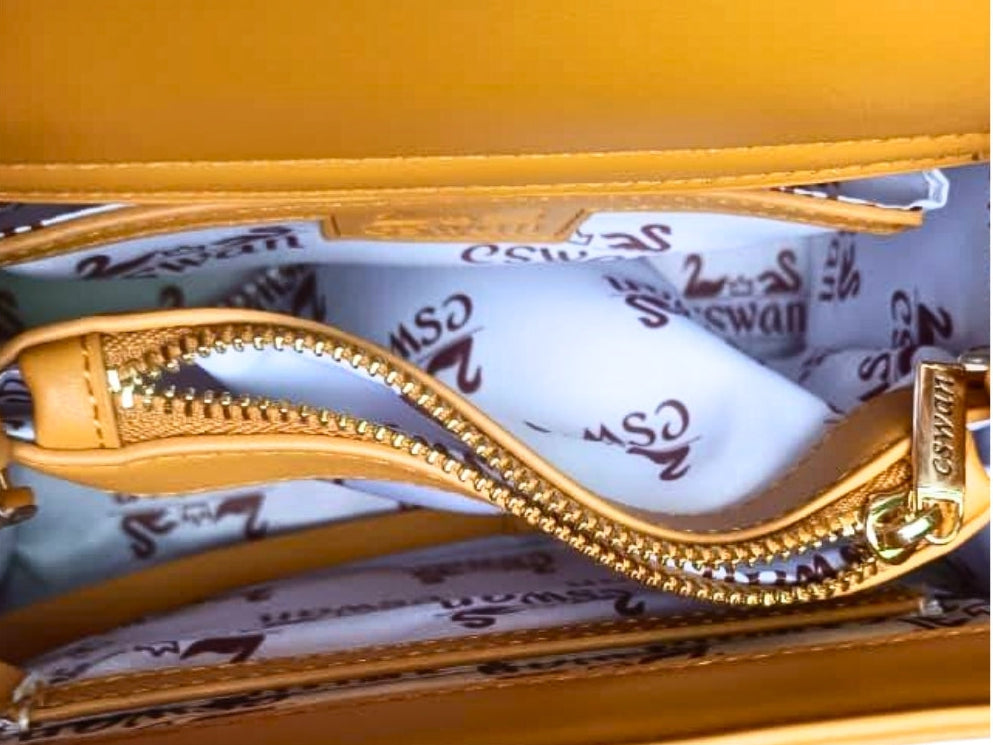 Interior view of the CSWAN Camel Tundra luxury handbag showcasing custom monogram lining, premium gold hardware, zippered center compartment, and organized storage pockets.