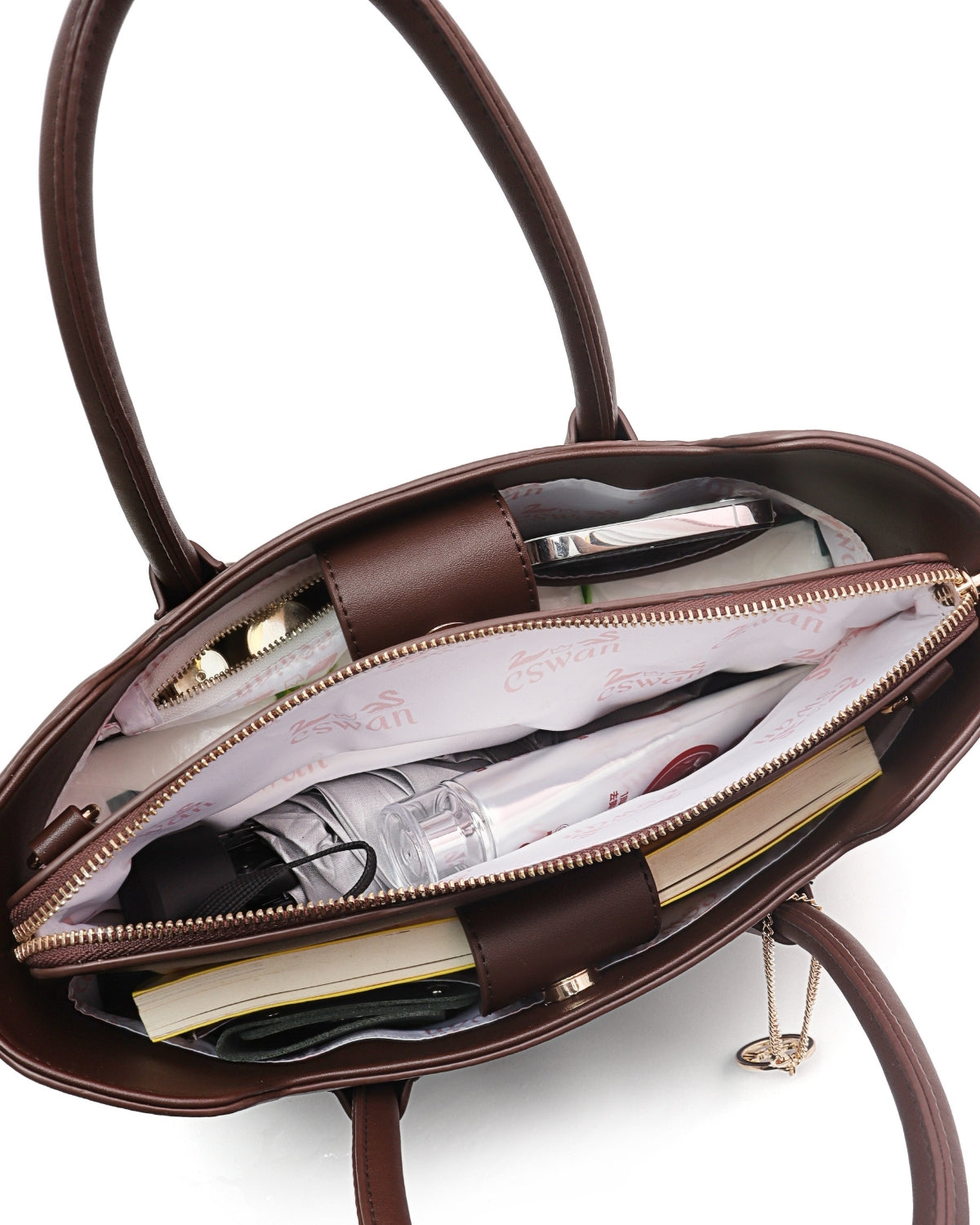 Interior view of Espresso Brown CSWAN medium tote packed with everyday essentials, featuring organized compartments, zip storage, and signature monogram lining